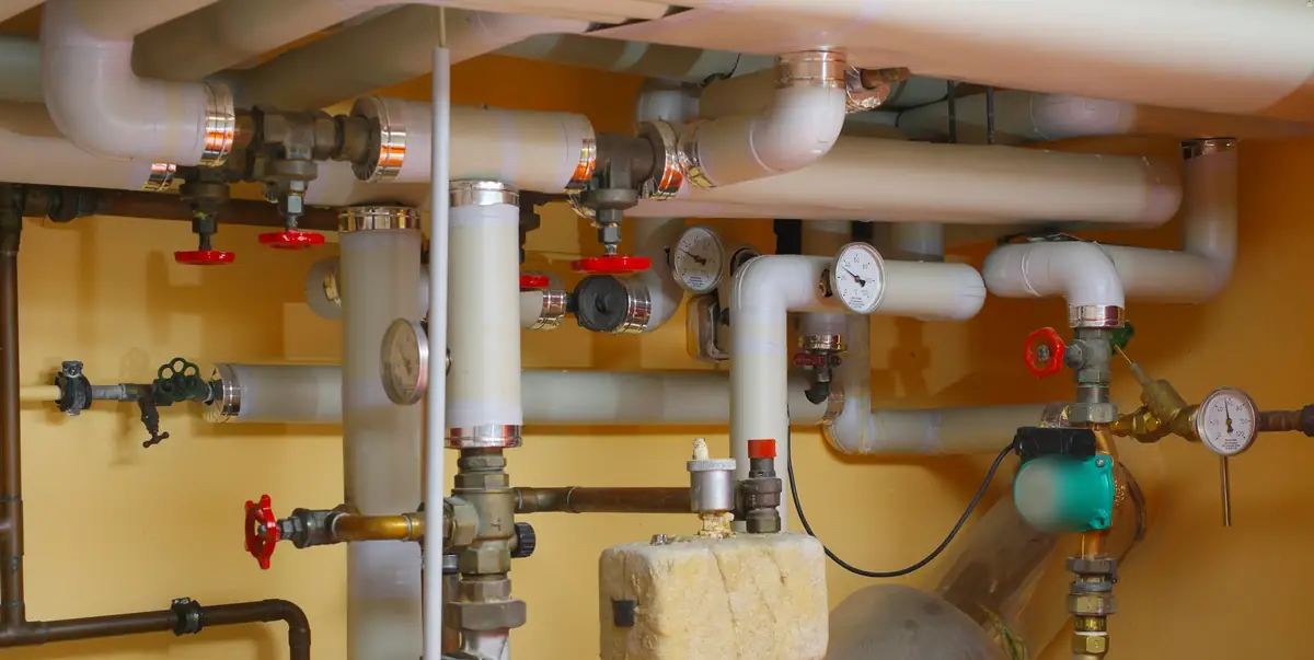 Insulated water pipes, valves and pressure gauges in a utility room
